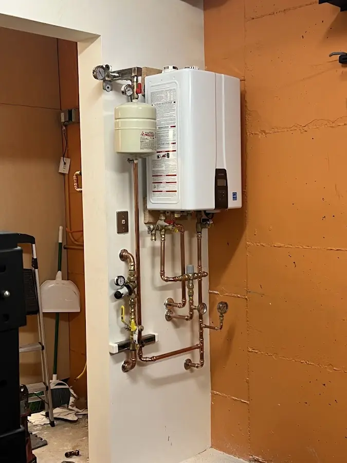 Plumbing technician inspecting water heater connections in Petal